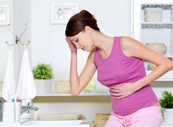 Избыток прогестерона при беременности может сопровождаться тошнотой, рвотными позывами, сильными головными болями 