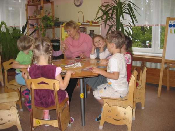 Педагог и дети сидят за круглым столом