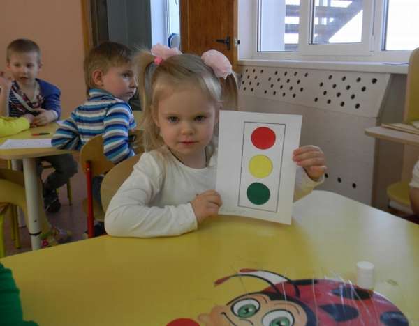 Девочка держит макет светофора из бумаги