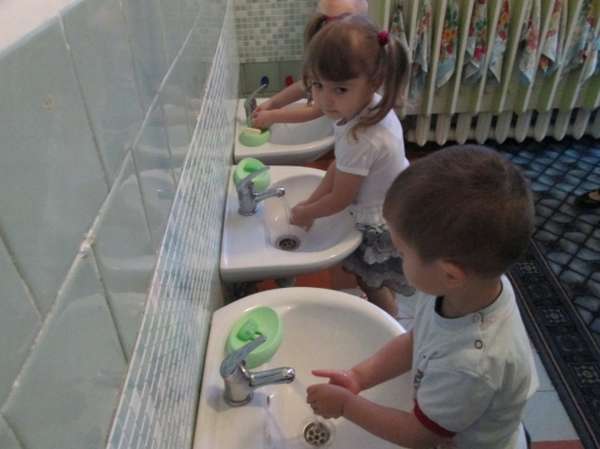 Трое детей моют руки