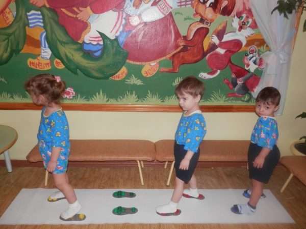Дети ходят по тренажёру с «приклеенными» ступнями