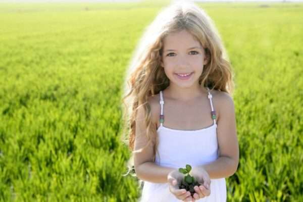 Девочка держит в руках растение