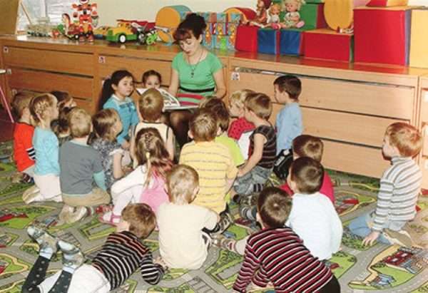 Воспитатель читает детям книжку