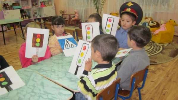 Дети держат в руках рисунки светофоров и дорожного знака