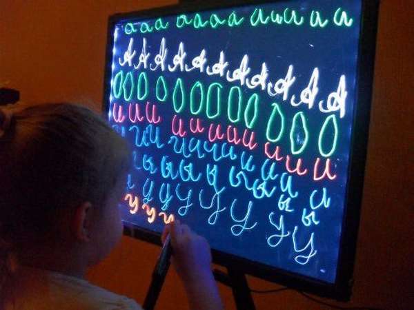 Девочка пишет буквы на led-доске