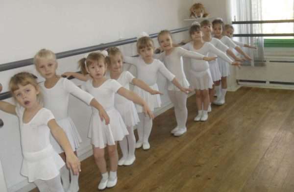 Девочки стоят у балетного станка