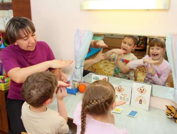 Воспитатель показывает на зеркальном отражении детей, как правильно выполнять упражнение