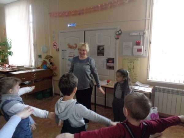 Дети и педагог выполняют упражнение с разведёнными в стороны руками