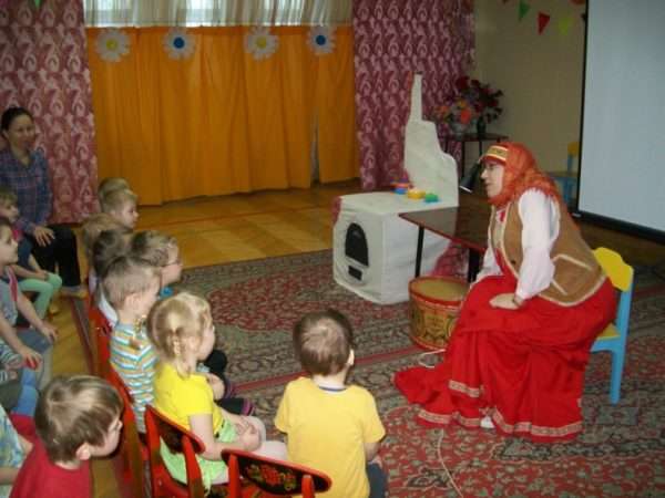 Воспитатель в русском народном костюме рассказывает дошкольникам сказку