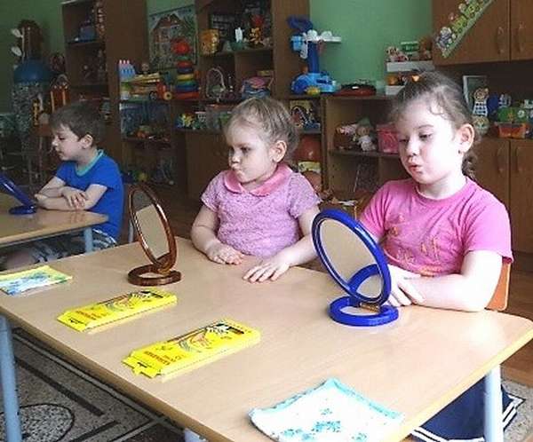 Дети выполняют артикуляционную гимнастику перед зеркалами
