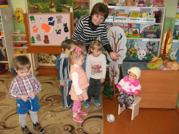 Воспитательница показывает детям куклу, сидящую на стуле
