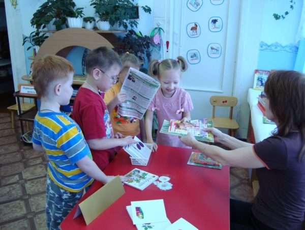 Дети и педагог играют в библиотеку