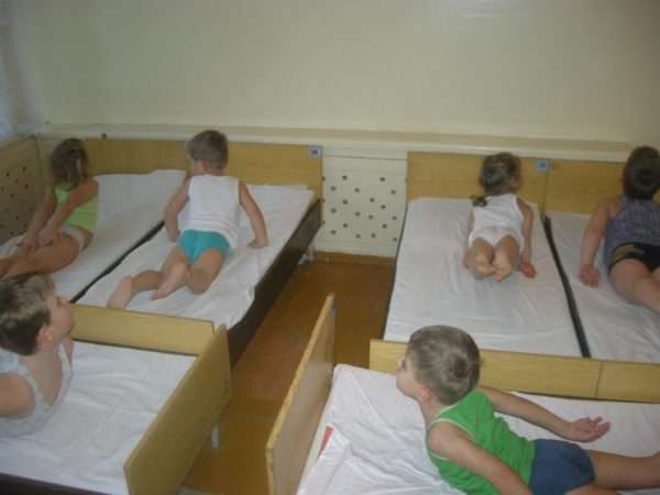 Дети выполняют упражнение, лёжа в кроватках