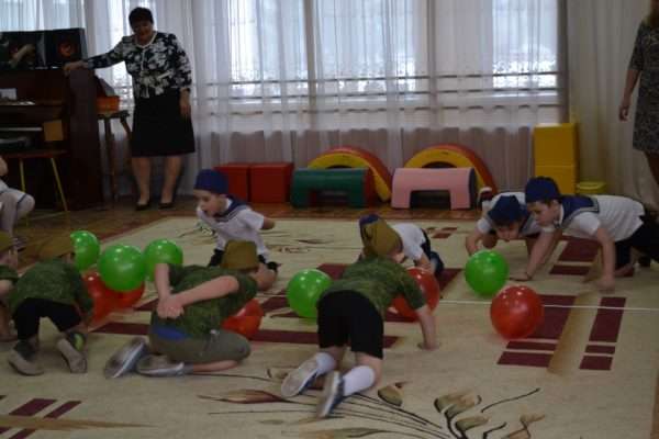 Дети ползут по полу в игре с мячами