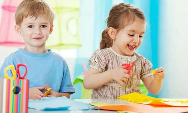 Мальчик и девочка вырезают из цветной бумаги