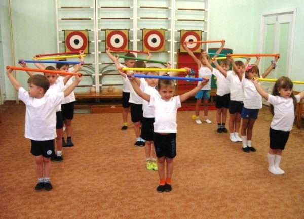 Дети выполняют упражнение с гимнастическими палками