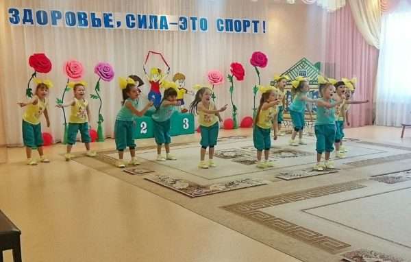 Дети танцуют и поют в зале на развлечении по ЗОЖ