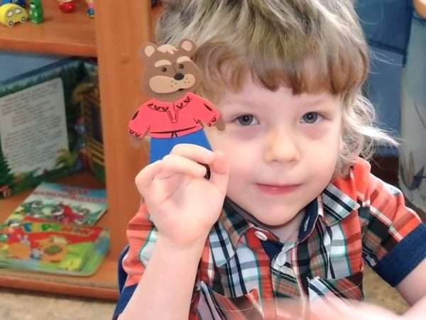 Мальчик держит фигурку картонного медведя