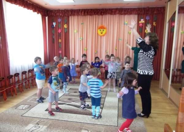 Дети и педагог выполняют упражнение, размахивая руками