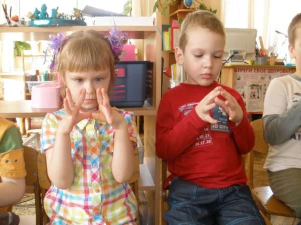 Мальчик и девочка выполняют пальчиковое упражнение «Пирамидка»