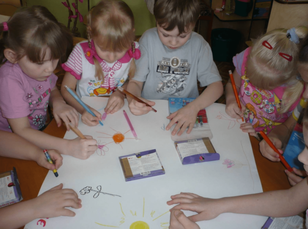 Дети делают совметный рисунок на листе ватмана