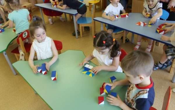 Дети за столами накладывают кубики на картинки