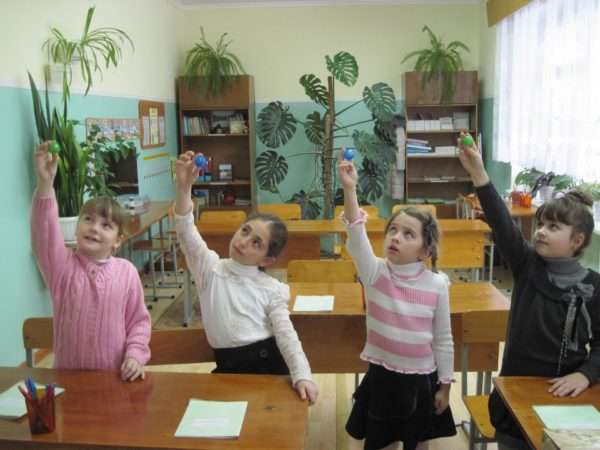Четыре девочки делают зрительную гимнастику с шариками в руках