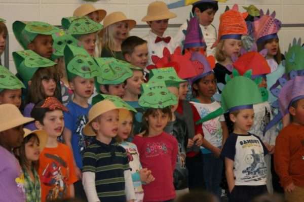 Дети поют хором в бумажных шапочках-масках
