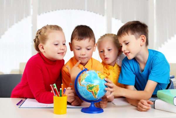Четверо детей рассматривают глобус