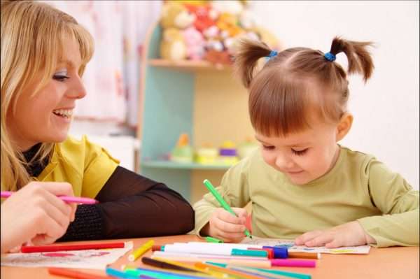 Девочка и педагог рисуют фломастерами