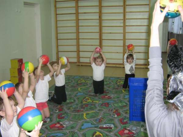 Дети выполняют упражнение с мячом в спотивном зале